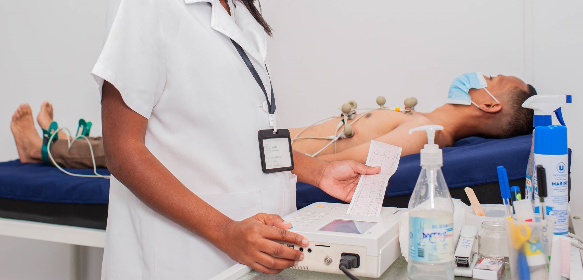Infirmière réalisant une électrocardiographie.